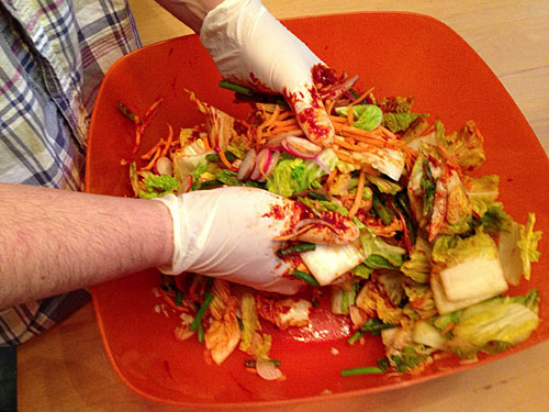 kimchi ingredients being massaged prior to fermentation 