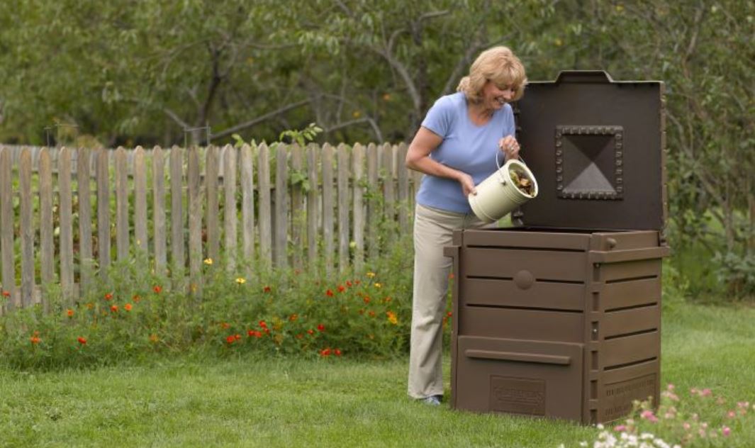 woman emptying food scraps into a composter